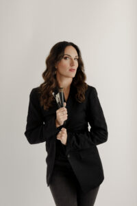 Beauty by Brigid professional makeup artist portrait holding brushes in branding photography studio