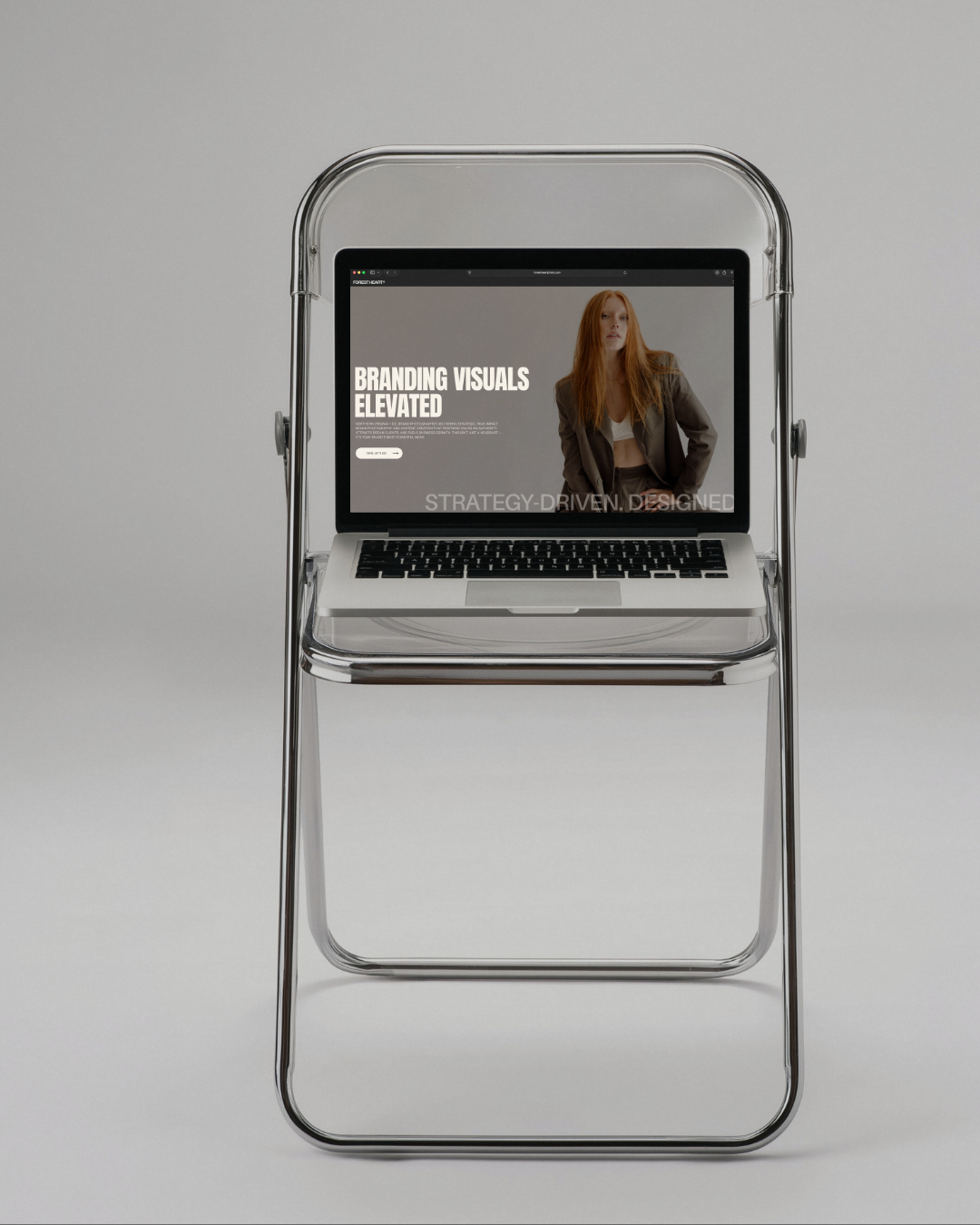 Minimal editorial branding photography setup featuring a laptop on a chrome chair for a blog about how branding photos improve SEO and online visibility
